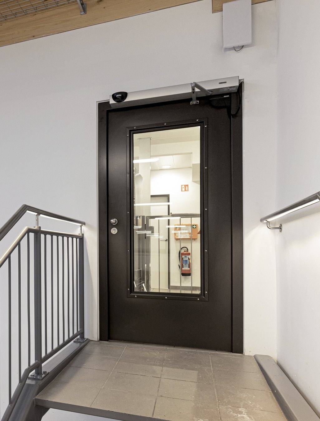 Stahltür im Treppenhaus mit obenliegendem Türschließer