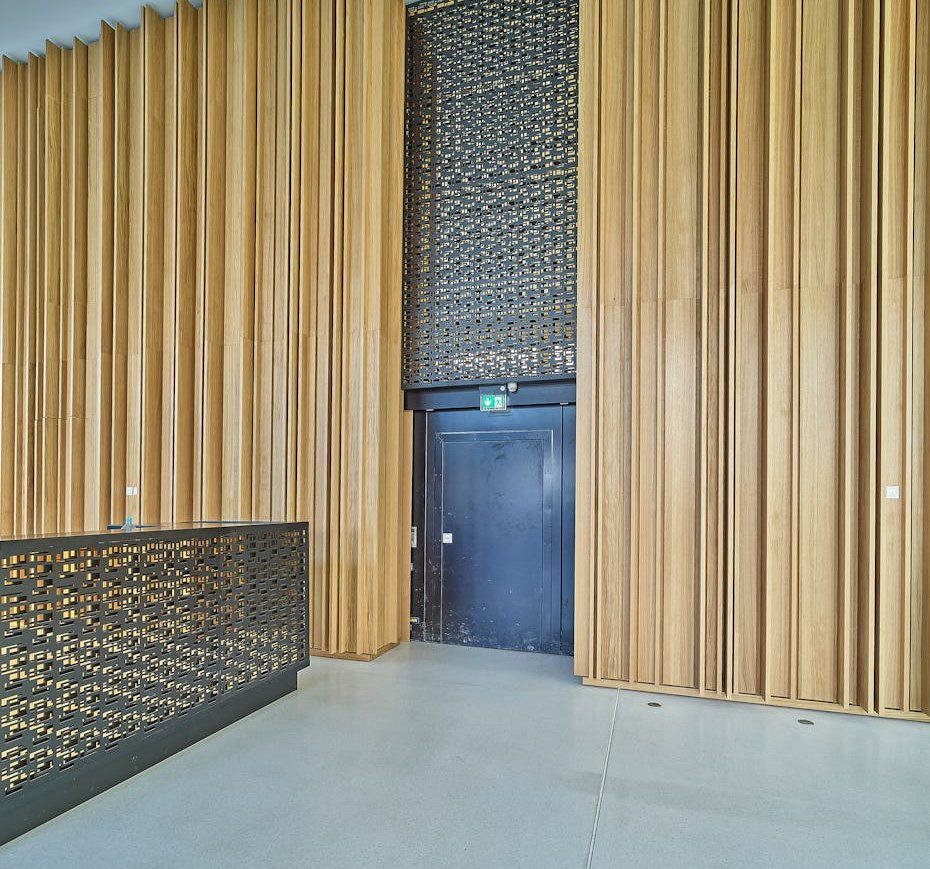 Stahltür mit Lichtausschnitt in einer Holzlamellenwand